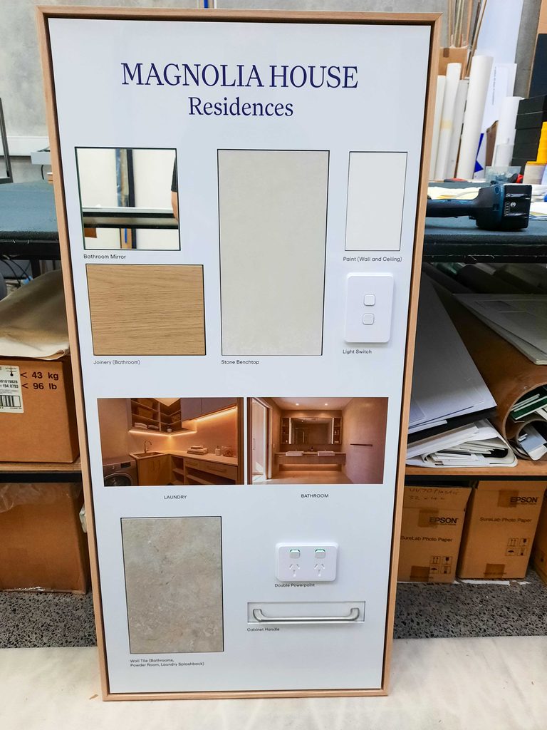Magnolia House bathroom and laundry finishes display board with material samples, fittings and a natural timber frame.